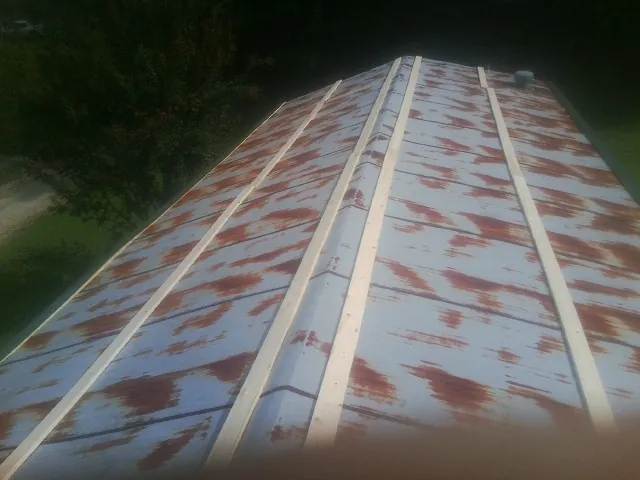 Rusted metal roof panels with new wood purlins before replacement — Storm Damage Roof Repair in Dinuba by Roofing Brothers
