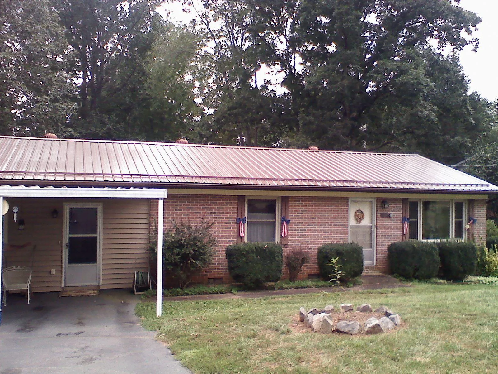 Bronze metal roof and carport on a brick ranch home — Roof Repair work by our crew in Dinuba