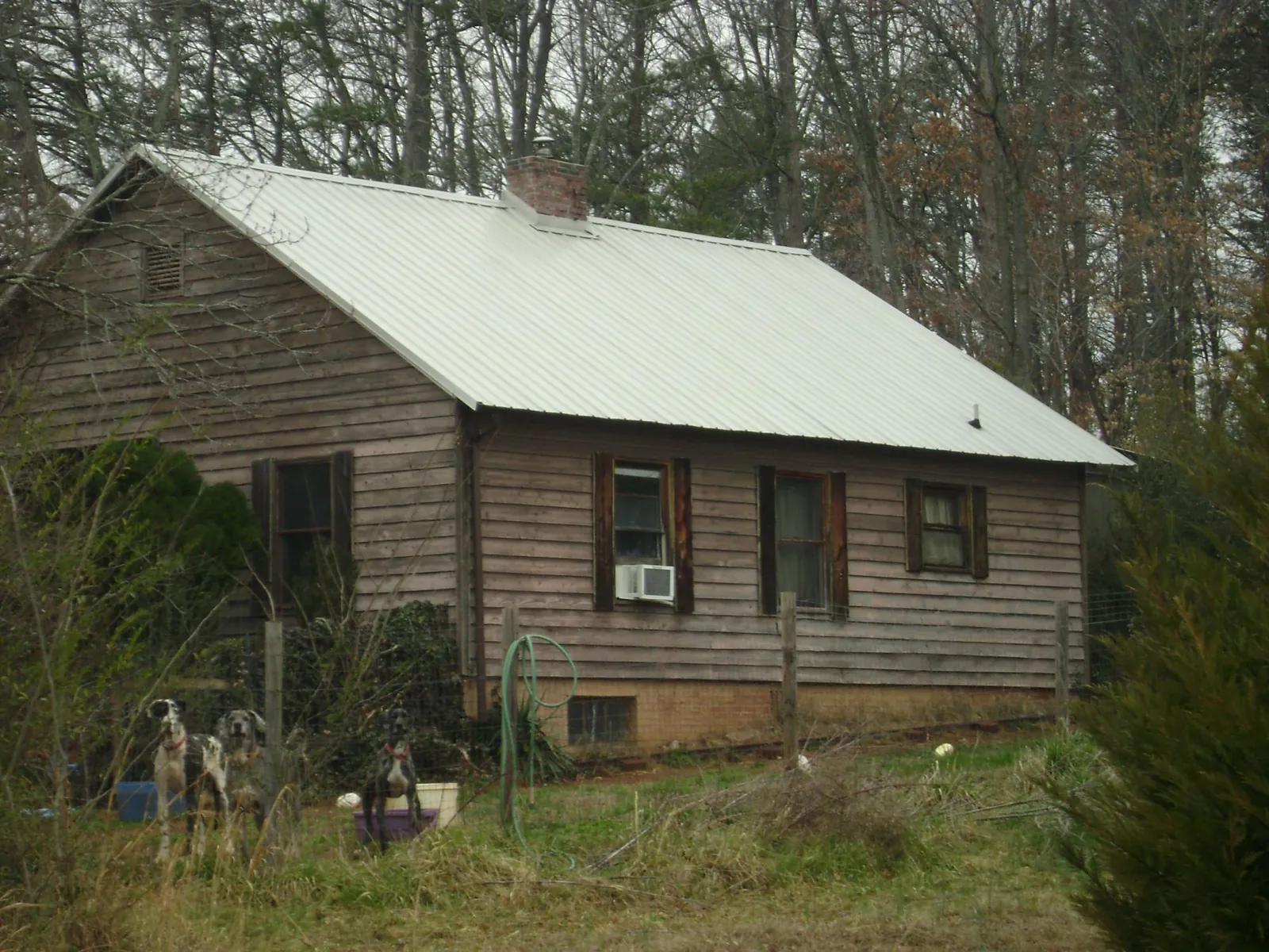 White metal roof on an old wood sided farmhouse, from a Metal Roof Installation job in Dinuba